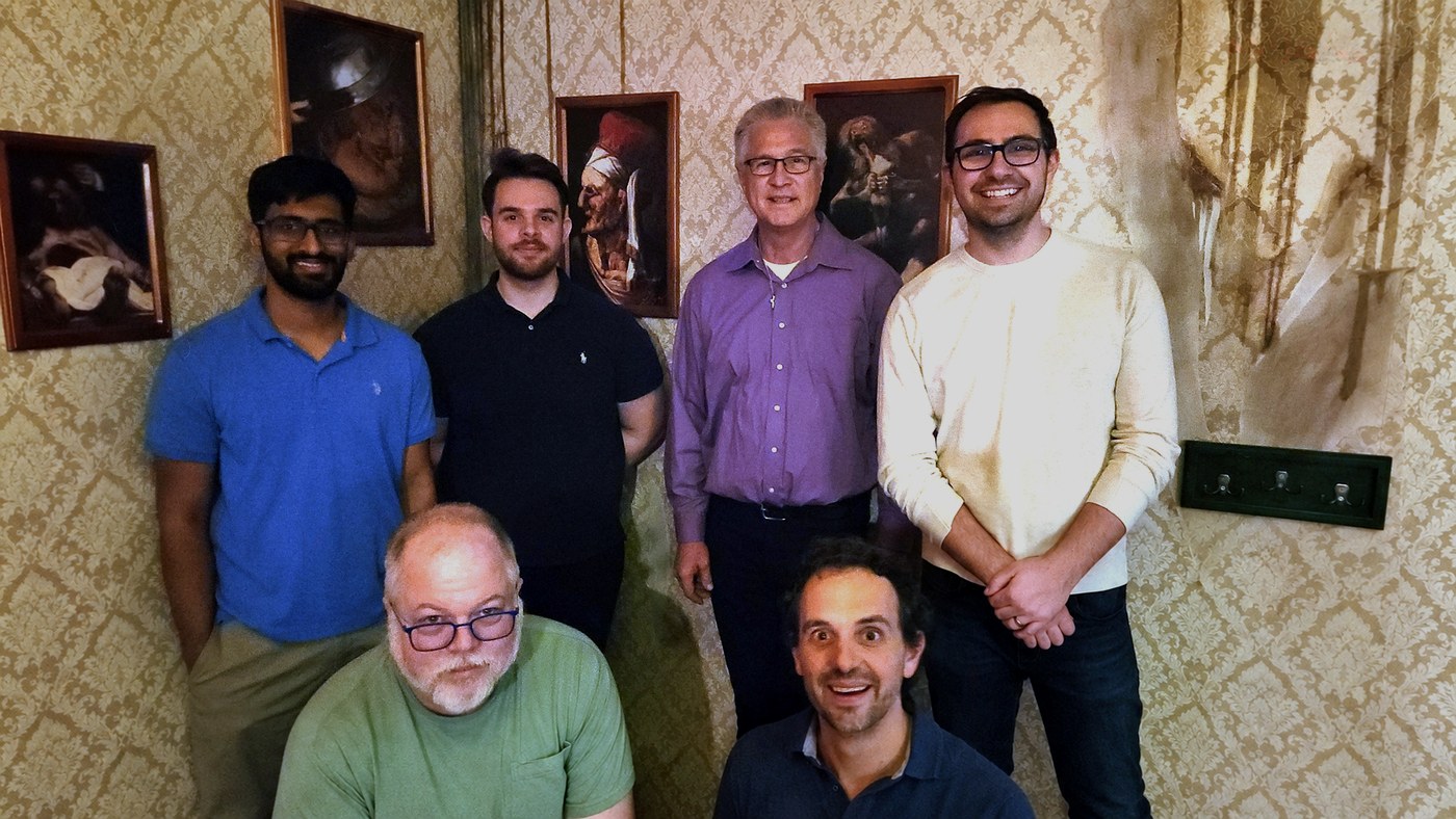 Corporate team poses inside Cannibal's Den during an escape room team-building event
