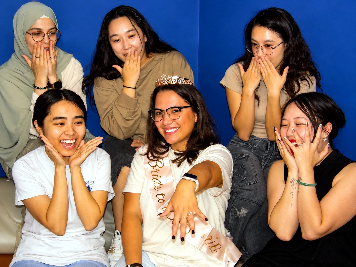 Bachelorette group reacts as the bride shows her ring during an escape room party in the Quest Room lobby